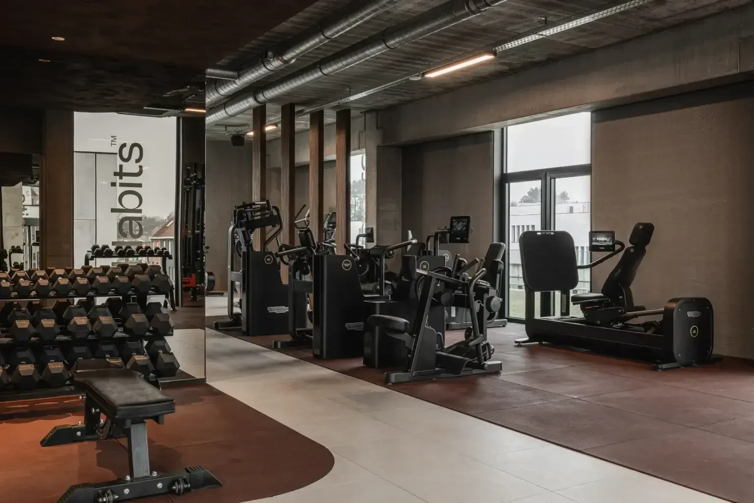 Habits Kortrijk met vrije gewichten, Technogym-toestellen en grote ramen