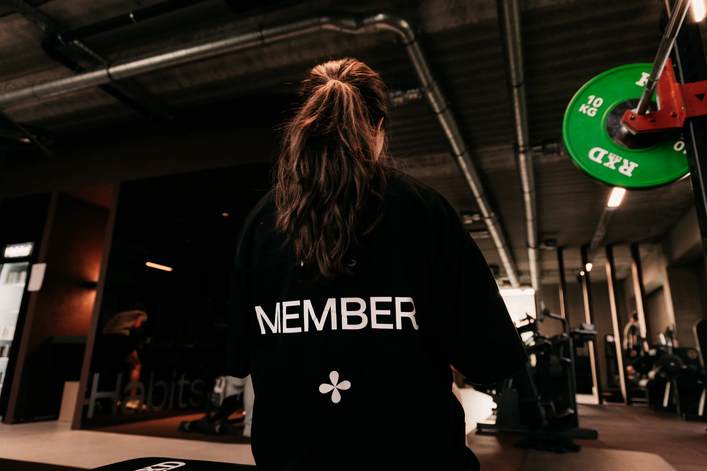 Een lid met het Member-shirt van Habits kijkt de club in